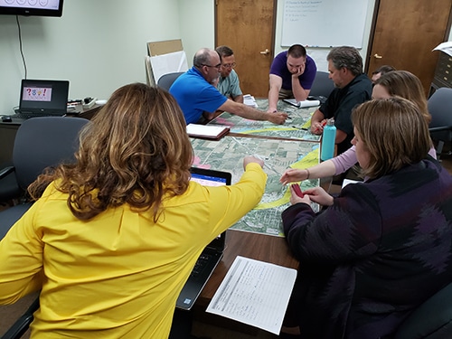 Picture of people looking over floodplain maps on a table.