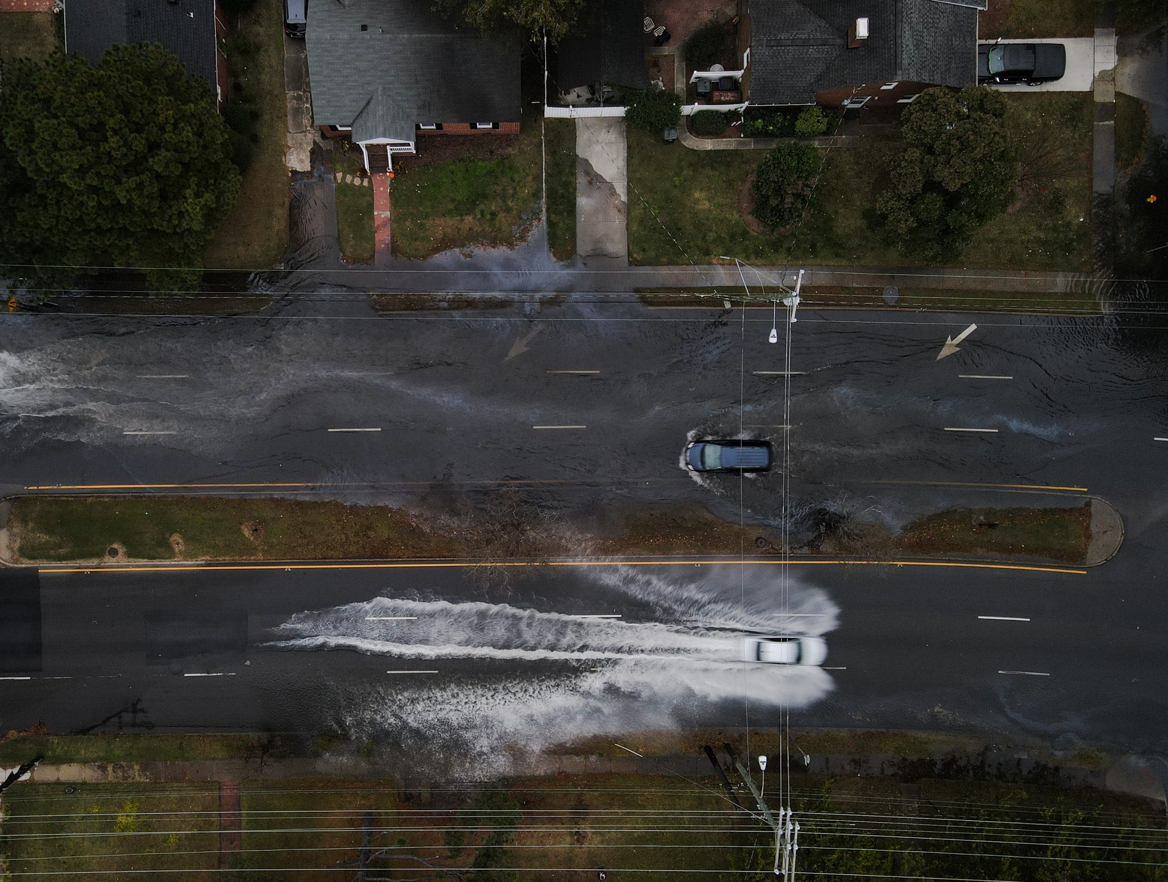 Cars driving in opposite directions down a flooded street.